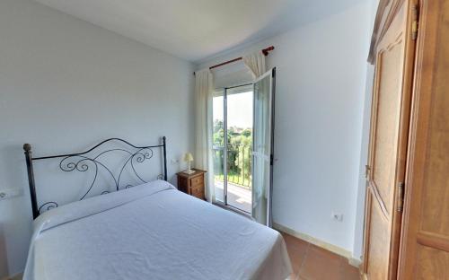 a bedroom with a bed and a large window at Apartamentos Costa Trafalgar in Zahora