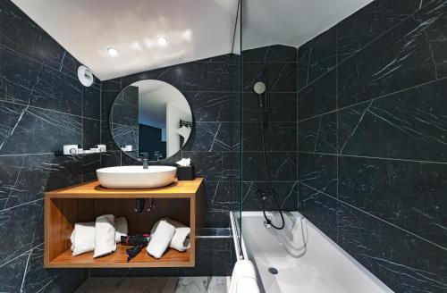 
a bathroom with a tub, sink, and mirror at Fahrenheit Seven Courchevel in Courchevel
