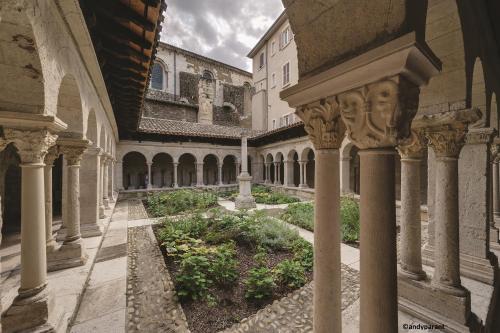 une cour d'un bâtiment avec des colonnes et un jardin dans l'établissement GITE PASQUIER, à Vienne