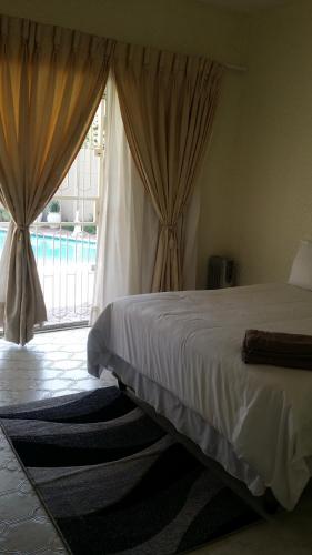 a bedroom with a bed and a large window at Moye Guest House in Benoni