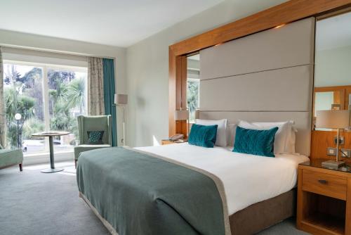 a bedroom with a large bed and a large window at Portmarnock Resort & Jameson Golf Links in Portmarnock