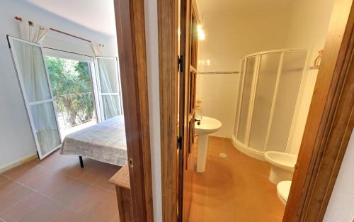 baño con lavabo y aseo y ventana en Apartamentos Costa Trafalgar, en Zahora