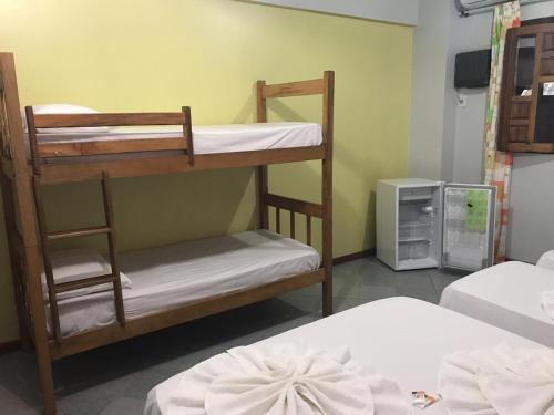 Zimmer mit 2 Etagenbetten und einem TV in der Unterkunft Pousada Sereia Dourada in Itacaré