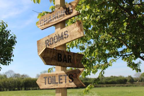 a wooden sign with arrows pointing in different directions at Badgers Mount Hotel in Earl Shilton