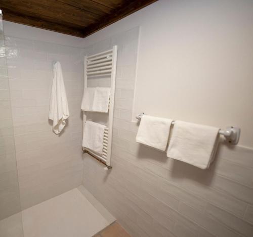 a bathroom with white towels hanging on a wall at Casa Rural Pradas in Montanejos