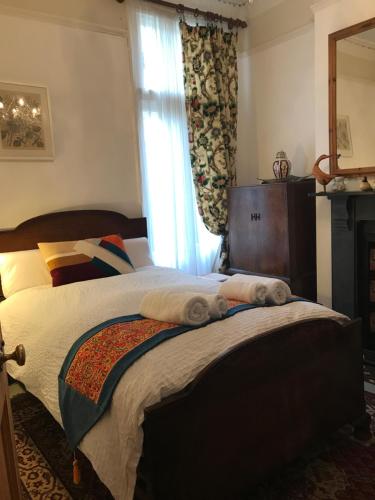 a bedroom with a bed with towels on it at Holmewood Homestay in London