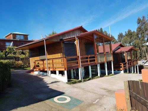 a wooden house with a driveway in front of it at WilAnn SPA in Pichilemu