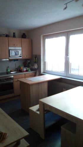 a kitchen with wooden cabinets and a large window at mosel ferienwohnung in Zell an der Mosel