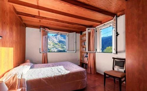 ein Schlafzimmer mit einem Bett und zwei Fenstern in der Unterkunft Villa el Manantial in Vega de San Mateo