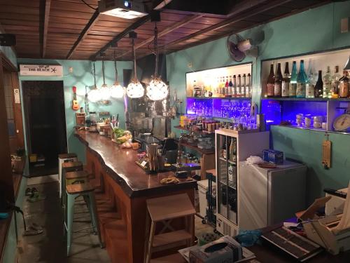 a bar with a counter in a room with bottles at Guest house & Bar Diamond Head in Mihana