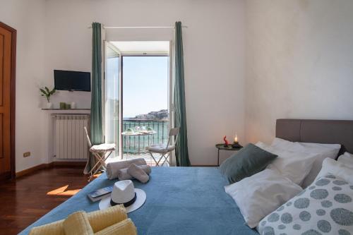 una camera da letto con un letto con un cappello sopra di NapoliCentro Mare - Sea View Rooms & Suites a Napoli