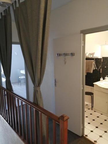 La salle de bains est pourvue d'un lavabo et d'une porte avec un rideau. dans l'établissement Relais de la Mothe LA SUITE, à Vrécourt