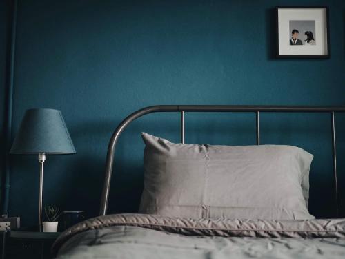 Yam Yen Hostel في لاكريبنغ لاد: غرفة نوم بسرير وجدار ازرق