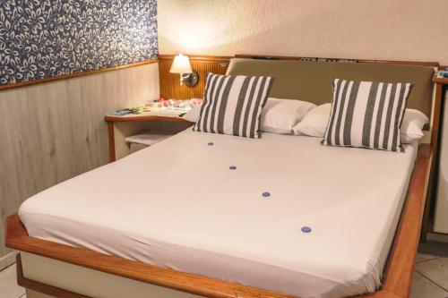 uma cama grande num pequeno quarto com uma mesa em MOTEL SHAMPOO (Adult Only) em Brusque