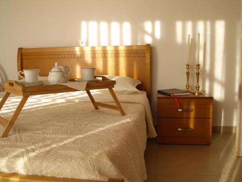 a bedroom with a bed with a wooden headboard and a table at Belvedere Adriatica in Qeparo