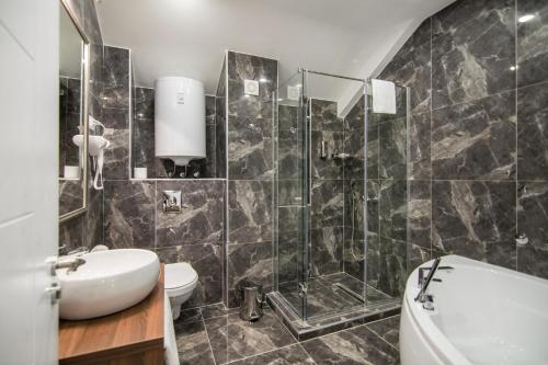 a bathroom with a shower and a toilet and a sink at Luxury Rooms Skadarlija in Belgrade