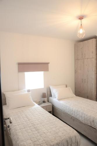 two beds sitting next to each other in a bedroom at Iconic Chania in Chania
