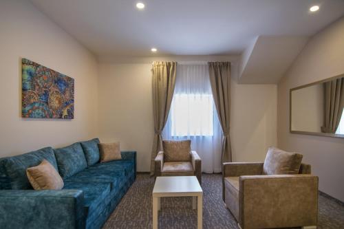 a living room with a blue couch and chairs at Luxury Rooms Skadarlija in Belgrade