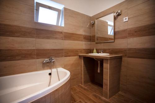 ein Badezimmer mit einer Badewanne und einem Waschbecken in der Unterkunft Vazsita ház in Erdőbénye
