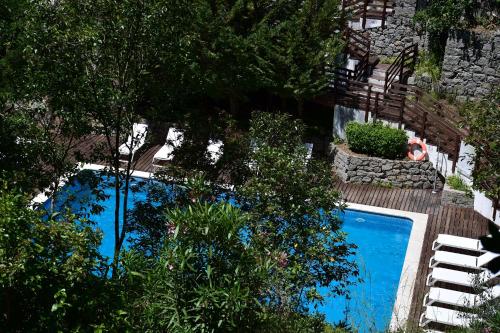 an overhead view of a swimming pool with chairs and trees at Central Monchique Hotel - Villa Termal Spa Resort - by Unlock Hotels in Monchique
