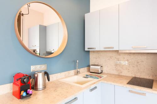 eine Küche mit einem Waschbecken und einem Spiegel in der Unterkunft Gray d'Albion YourHostHelper in Cannes