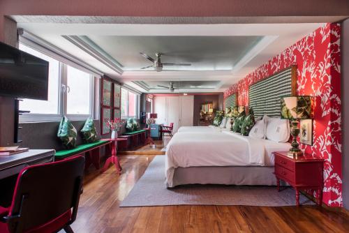 a bedroom with a large bed and a red wall at Pug Seal Coyoacan in Mexico City