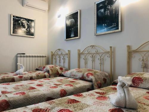 a bedroom with two beds and pictures on the wall at La casa di Chloé in Alezio