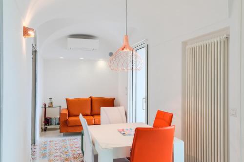 a dining room with a white table and orange chairs at The Lodge in Scala