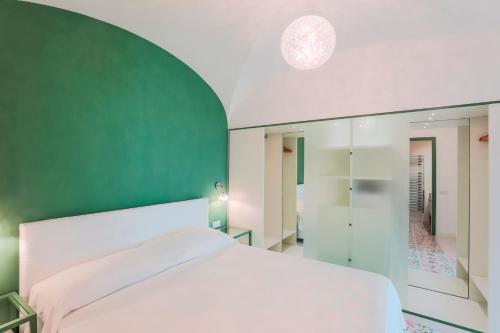 sypialnia z białym łóżkiem i zieloną ścianą w obiekcie The Lodge w mieście Scala