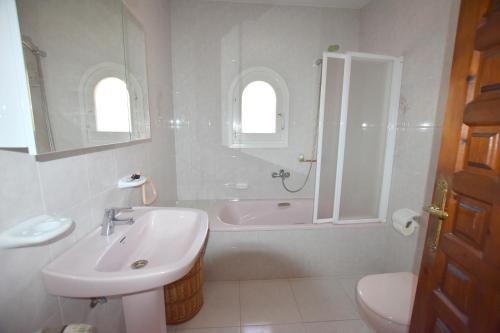 a bathroom with a sink and a tub and a toilet at Casa Mozart in Jávea