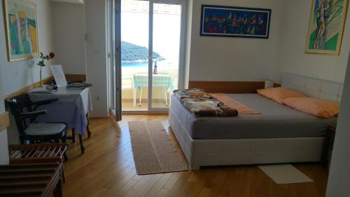 a bedroom with a bed and a table and a window at Nik 1 the Views Apartment in Dubrovnik