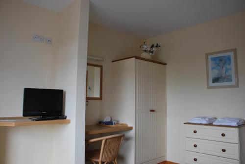 a bedroom with a bed and a tv and a cabinet at Kemar House post code F26RR28 in Belmullet