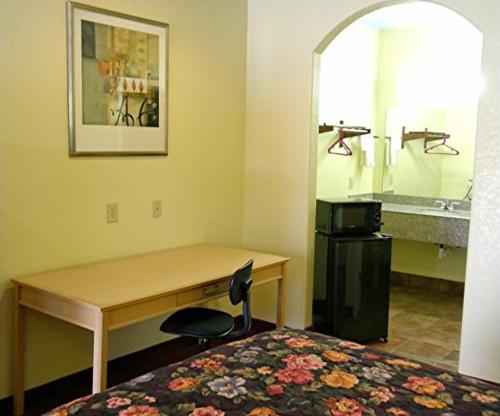 a hotel room with a desk and a bed and a sink at Matador Motel in San Antonio