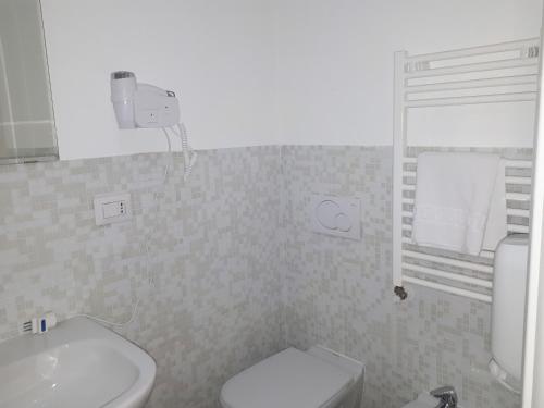 bagno con servizi igienici bianchi e lavandino di La Rosa dei Sassi 2 a Matera