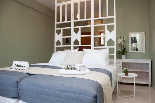 a bedroom with a blue bed with a white headboard at Mojito Elegant Studios in Plataniás