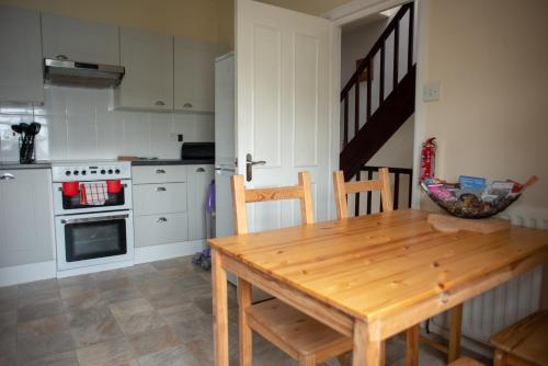 a kitchen with a wooden dining table and a stove at Bracken Crag in Bowness-on-Windermere