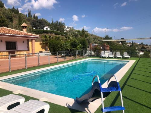 una piscina con dos sillas y una casa en Casa Olivia, en Cómpeta