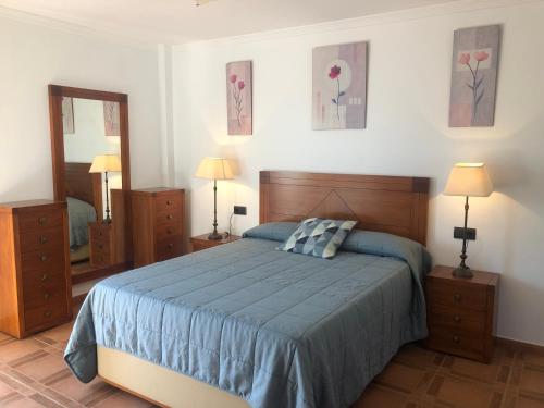 a bedroom with a bed and two dressers and a mirror at Casa Olivia in Cómpeta