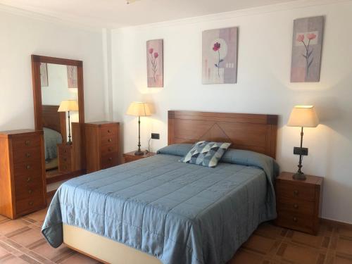 Un dormitorio con una cama y dos cómodas y un espejo. en Casa Olivia, en Cómpeta