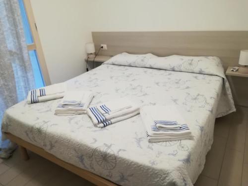 een bed met witte lakens en handdoeken erop bij La Favola di Elsa in Castelsardo