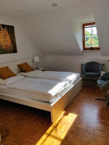 a bedroom with a large white bed and a chair at Gästehaus der Abtei Sayn in Bendorf