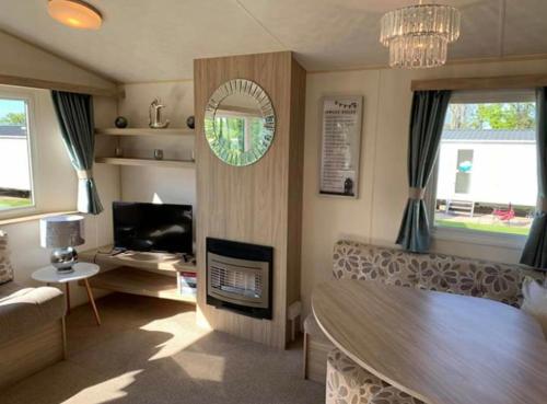 a living room with a table and a couch and a television at Edinburgh, seton sands in Port Seton