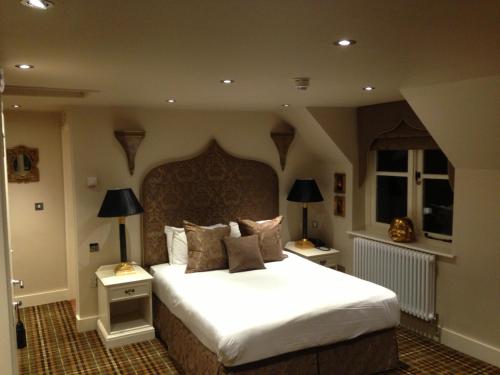 a bedroom with a large white bed with two lamps at The White Hart in Great Yeldham