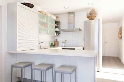 una cocina con encimera blanca y taburetes en PillowAbroad - Poris Vista Mar, en Porís de Abona