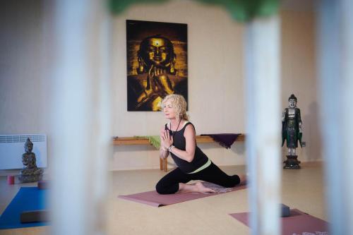 a woman doing yoga in a room with a statue at Výhledna in Beroun