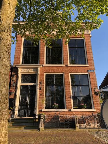 a brick building with black doors and windows at B&B Diepzicht in Dokkum