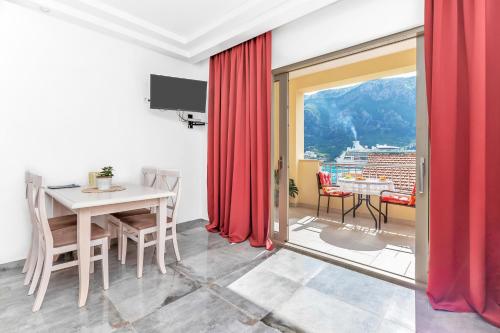 a dining room with red curtains and a table at Apartments Castello in Kotor