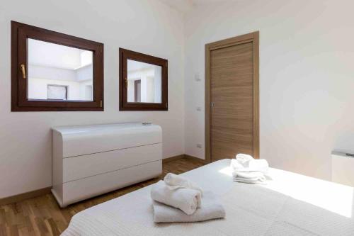 a white bedroom with a mirror and towels on a bed at Palermo Blu - Palazzo Quaroni in Palermo