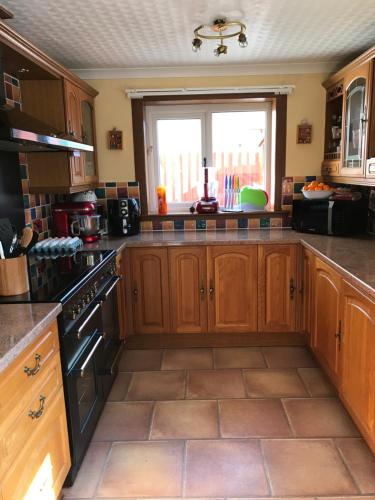 a kitchen with wooden cabinets and a window at Inchrye Bed & Breakfast in Inverness