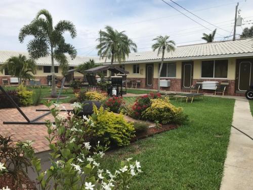 a house with a yard with flowers and plants at Shell Motel Hollywood in Hollywood